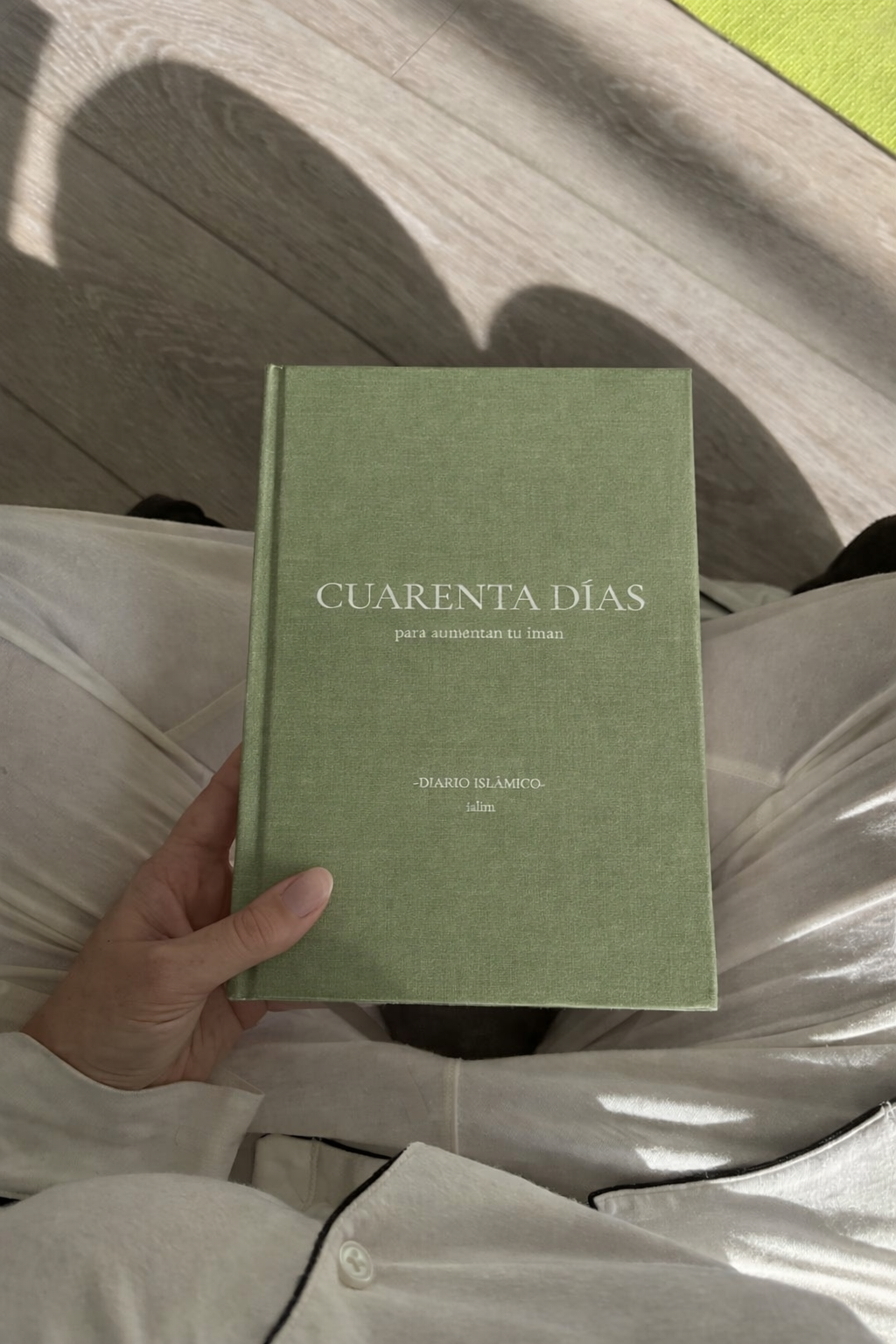 Persona sosteniendo el diario islámico Cuarenta Días de Ialim de tapa de lino verde